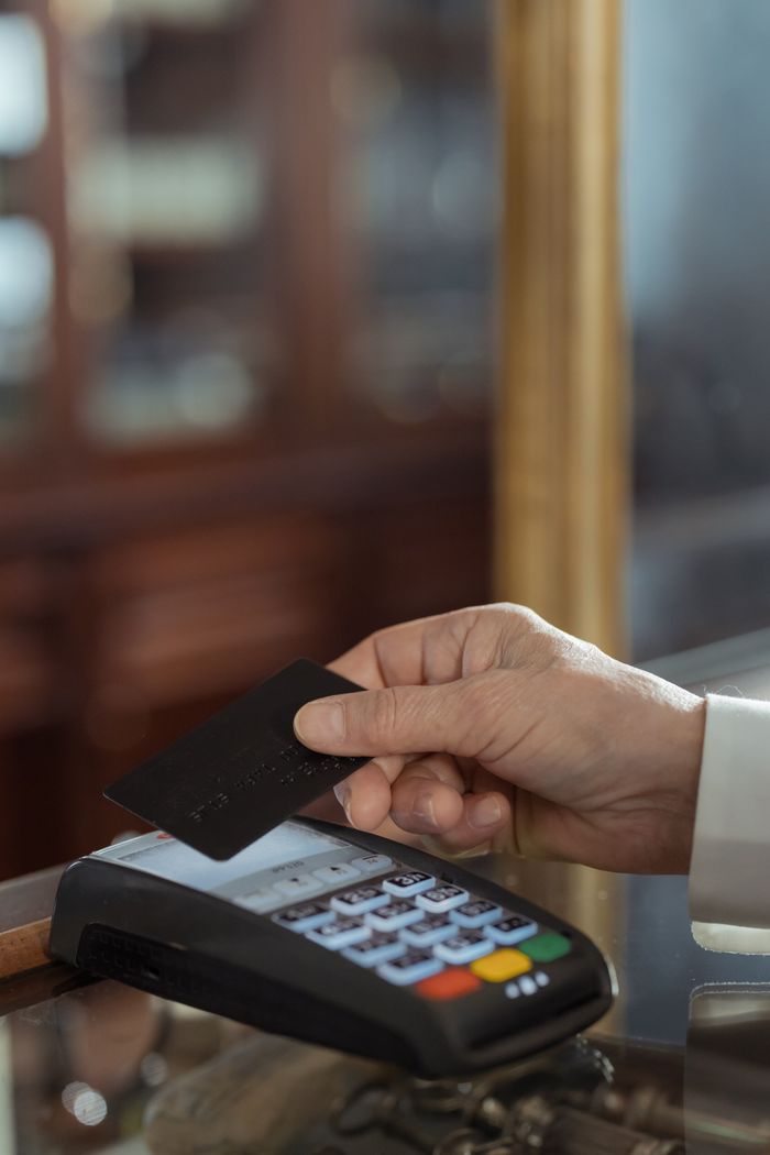 Customer tapping a loyalty card at a store checkout counter